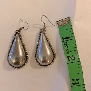 Silver tear drop shaped earrings with beaded trim d detailing.